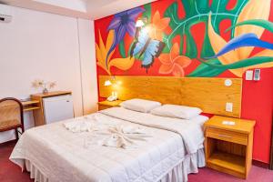 a bedroom with a bed with a painting on the wall at Los Lagos Resort Hotel in Capiatá