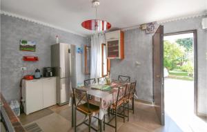 Il comprend une cuisine équipée d'une table, de chaises et d'un réfrigérateur. dans l'établissement Gorgeous Home In San Zenone D, Ezzelini With Kitchen, à Fonte