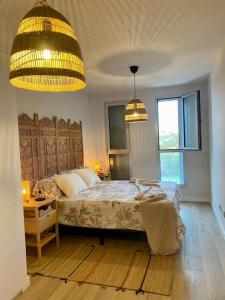 een slaapkamer met een bed en een tafel en twee verlichting bij Casa Arirni in Las Palmas de Gran Canaria