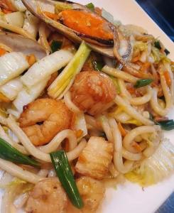 a plate of food with shrimp noodles and vegetables at Atteriya CHILL in Arugam Bay
