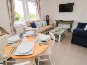 a living room with a table and a couch at 5 West Winds in Eyemouth