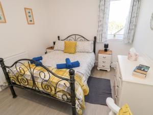 a bedroom with a bed and a white desk at 5 West Winds in Eyemouth