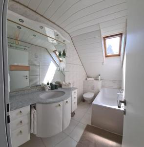 a white bathroom with a sink and a toilet at Milladon Logement en face de l'EPFL in Ecublens