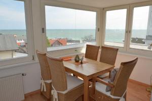 comedor con mesa, sillas y ventanas en Villa Johanna mit herrlichem Seeblick en Sassnitz