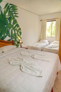 a bedroom with two beds with white sheets and a window at Los Lagos Resort Hotel in Capiatá