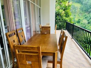 a dining room with a table and chairs on a balcony at Ella Tea Heaven Resort in Ella