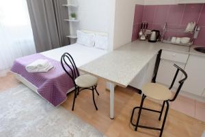 a small kitchen with a table and two chairs at Aparthotel Almarent in Almaty