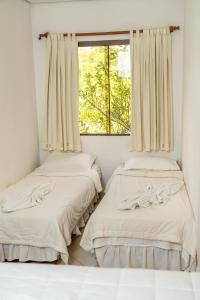 two beds in a room with a window at Los Lagos Resort Hotel in Capiatá