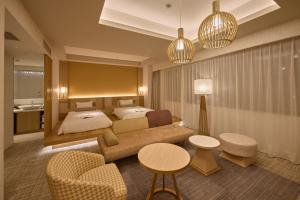 金沢市にあるホテルインターゲート金沢のベッド、ソファ、テーブルが備わるホテルルームです。