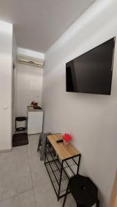 a living room with a table and a television on a wall at ESCAPE in Nydri