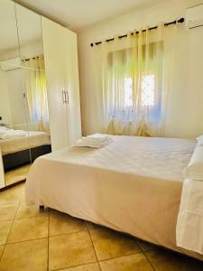 a bedroom with a large white bed and a mirror at La casetta di Giulio II in Ostia Antica