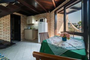 a kitchen with a table with a vase of flowers on it at Pousada Albacora in Bombinhas