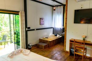 a bedroom with a tub and a bed and a table at Los Lagos Resort Hotel in Capiatá