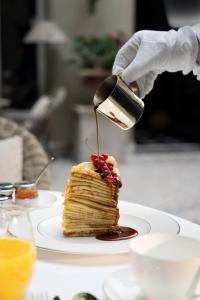 a person is pouring syrup on a stack of pancakes at CH Longstay 2 in Kortrijk