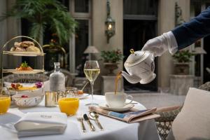 a person is pouring a cup of wine on a table at CH Longstay 2 in Kortrijk