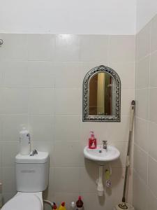 een badkamer met een toilet, een wastafel en een spiegel bij Homestay AAA Bukit Keluang Besut Terengganu in Kampung Raja