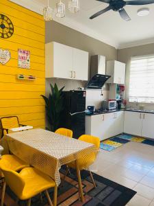 een keuken met een tafel en gele muren bij Homestay AAA Bukit Keluang Besut Terengganu in Kampung Raja