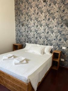 a bedroom with a bed and a wall with a wallpaper at civico settee in Rome