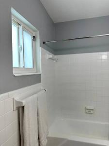 - une salle de bains blanche avec une fenêtre et une serviette dans l'établissement Large 2 bedroom Comfortable Private house with private Pool, à Fort Lauderdale