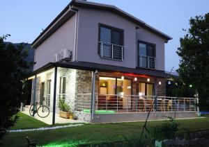 una casa con un gran balcón en el patio en Villa Green, en Muğla