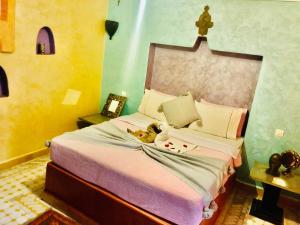 um quarto com uma cama com um urso de peluche em Riad Layla Rouge em Marrakech