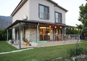Una casa con un gran balcón al costado de ella. en Villa Green, en Muğla
