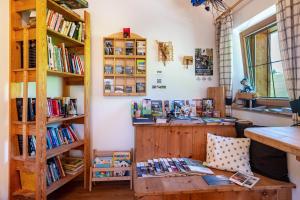 a room with a table and bookshelves with books at Mongaduierhof Apt Panorama in Umes