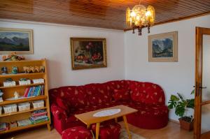 salon z czerwoną kanapą i stołem w obiekcie Ubytovanie u Eriky w mieście Hrabušice