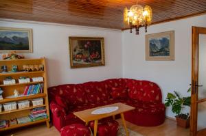 a living room with a red couch and a table at Ubytovanie u Eriky in Hrabušice