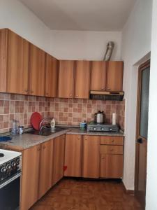 a kitchen with wooden cabinets and a stove at The quiet house in Durrës +53 photos
