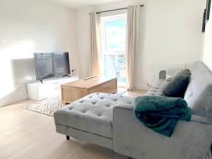 a living room with a couch and a television at Home Crowd Luxury Apartments - White Rose Apartments in Doncaster