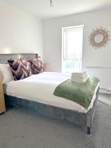 a bedroom with a large bed with a mirror on the wall at Home Crowd Luxury Apartments - White Rose Apartments in Doncaster