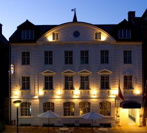 a large white building with lights in front of it at Palads Hotel in Viborg