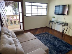 a living room with a couch and a television at Casa Roosevelt in Uberlândia