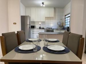 uma cozinha com uma mesa com pratos e copos em Casa Roosevelt em Uberlândia