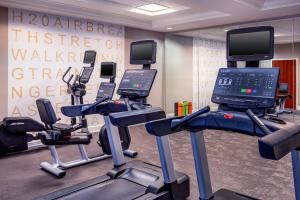 a gym with treadmills and exercise bikes in front of a wall at Residence Inn by Marriott Chesapeake Greenbrier in Chesapeake