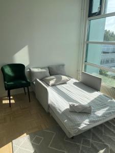 een slaapkamer met een bed, een stoel en een raam bij Modern and Cozy apartment with Sauna2 in Espoo