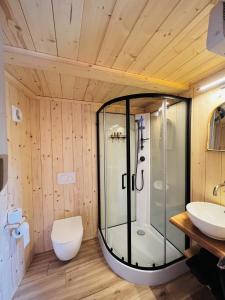 La salle de bains est pourvue d'une douche en verre et de toilettes. dans l'établissement Magnolia Hoeve - overnachten in de natuur op een paarden resort, 
