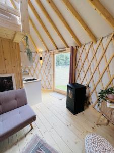 uma sala de estar com um fogão numa casa em Magnolia Hoeve - overnachten in de natuur op een paarden resort 