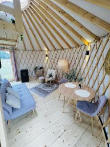 um quarto com uma mesa e cadeiras numa tenda em Magnolia Hoeve - overnachten in de natuur op een paarden resort 