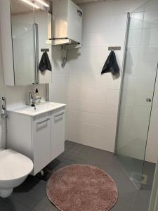 een badkamer met een toilet, een wastafel en een douche bij Modern and Cozy apartment with Sauna2 in Espoo