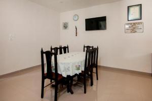 uma mesa e cadeiras com uma mesa e um relógio na parede em Hotel Wisata Samosir By Helocus em Pangururan