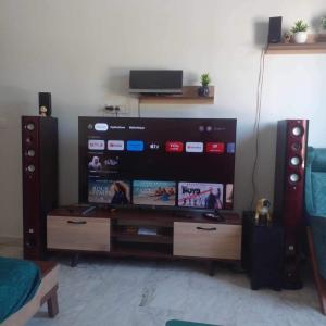 a living room with a flat screen tv and speakers at La perle bleue de Sarah in Kheredine