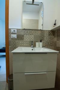 eine Küche mit einem weißen Waschbecken und einem Spiegel in der Unterkunft Casa Bianca in Conversano