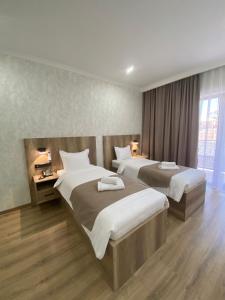 Cette chambre comprend 2 lits et une fenêtre. dans l'établissement KORKEM Palace Hotel and Spa, à Chimkent