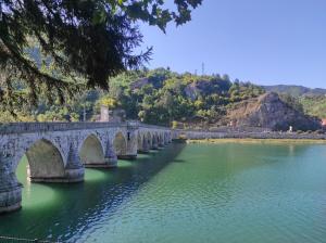un puente de piedra sobre un río con agua verde en Spa intimo Višegrad, en Višegrad
