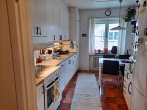 une cuisine avec des placards blancs, une table et une salle à manger dans l'établissement Karls ställe, à Östersund