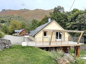 a house with a wooden deck in a yard at A Cœur d'Hêtre in Estaing
