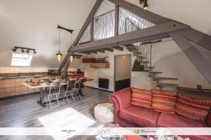 Estaing的住宿－A Cœur d'Hêtre，一间带红色沙发的客厅和一间厨房