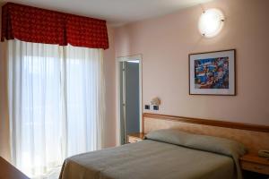 a bedroom with a bed and a large window at Hotel de Paris in Lido di Savio